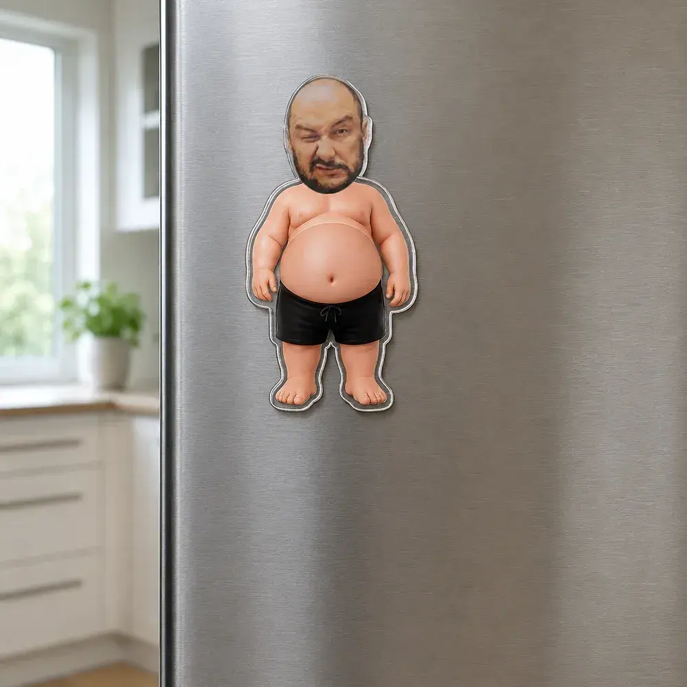 Akrylowa figurka z twarzą mężczyzny przyczepiona do drzwi lodówki.